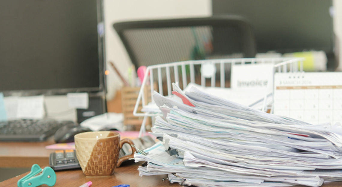 Stack of newspapers and printed documents representing customer complaints and difficult client communication
