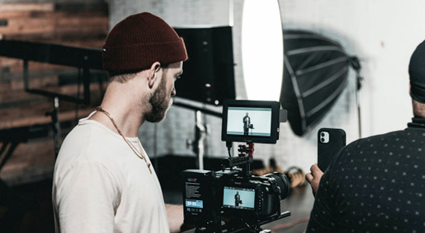 Person working at a camera and filming setup representing social media investment decisions for small brands