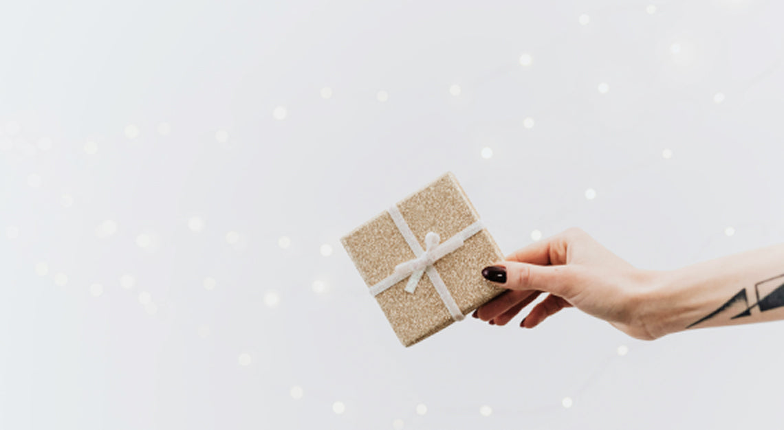 Person holding a wrapped gift package representing product packaging and first impressions before purchase